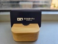 창가의 나무 명함꽂이에 놓인 모모법률사무소 명함
